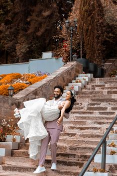 A joyful couple celebrating their wedding day on a scenic stone staircase outdoors.