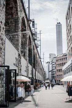 晴朗的天空下，繁华的城市街道上，商店、行人和石质建筑构成了它的特色