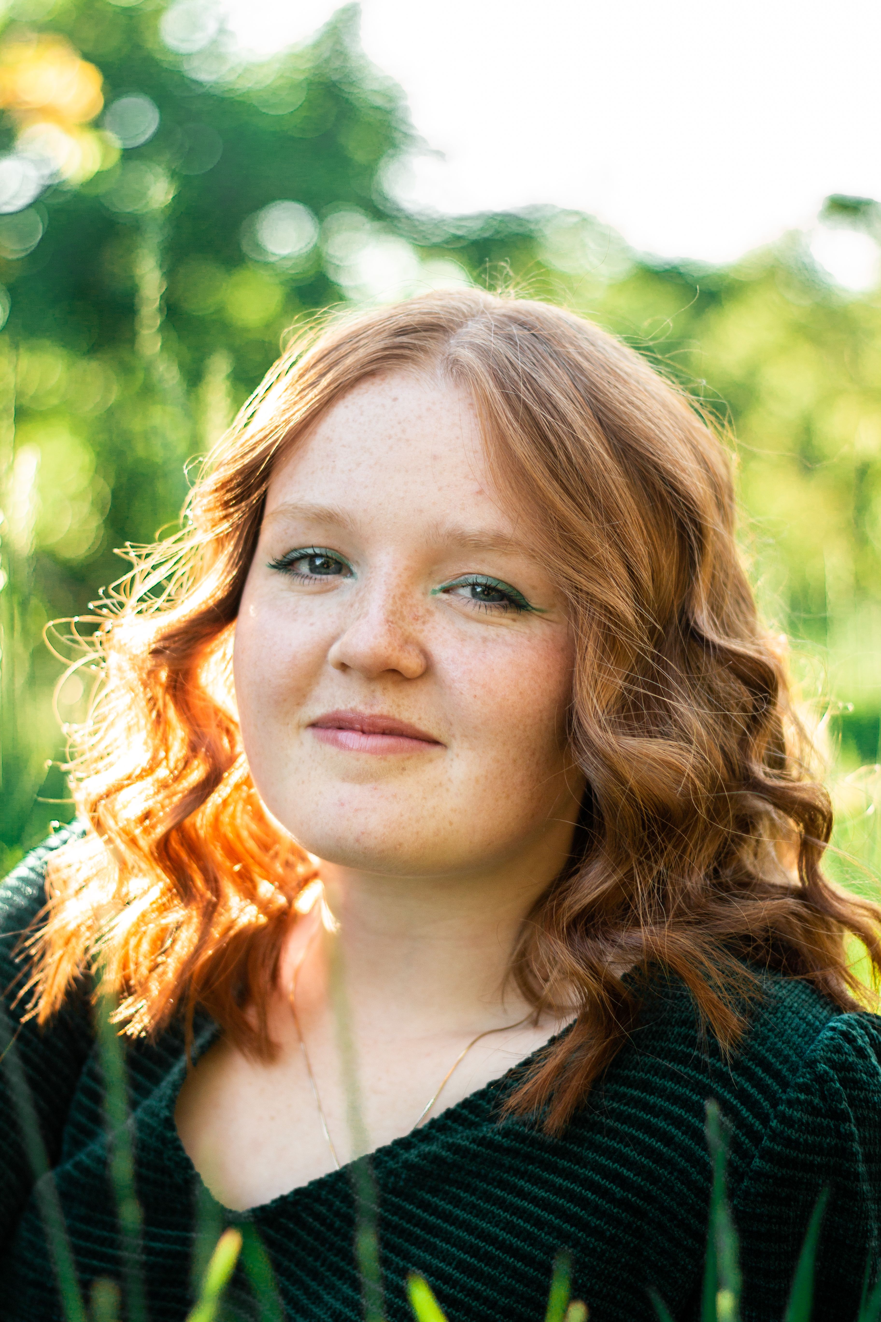 Red-haired woman with freckles enjoying a summer day outdoors.
