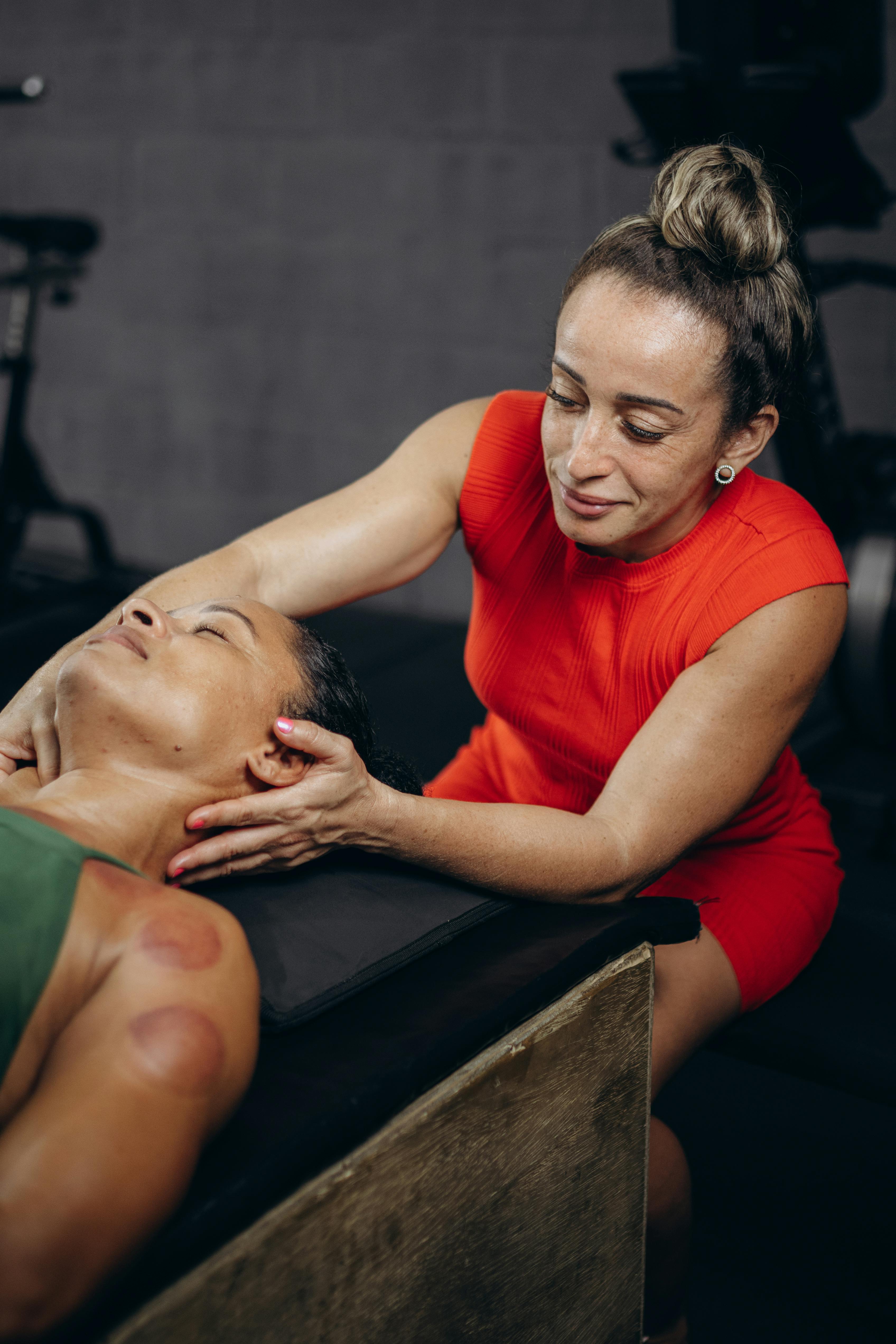 A therapist performs myofascial release on a relaxed woman indoors.