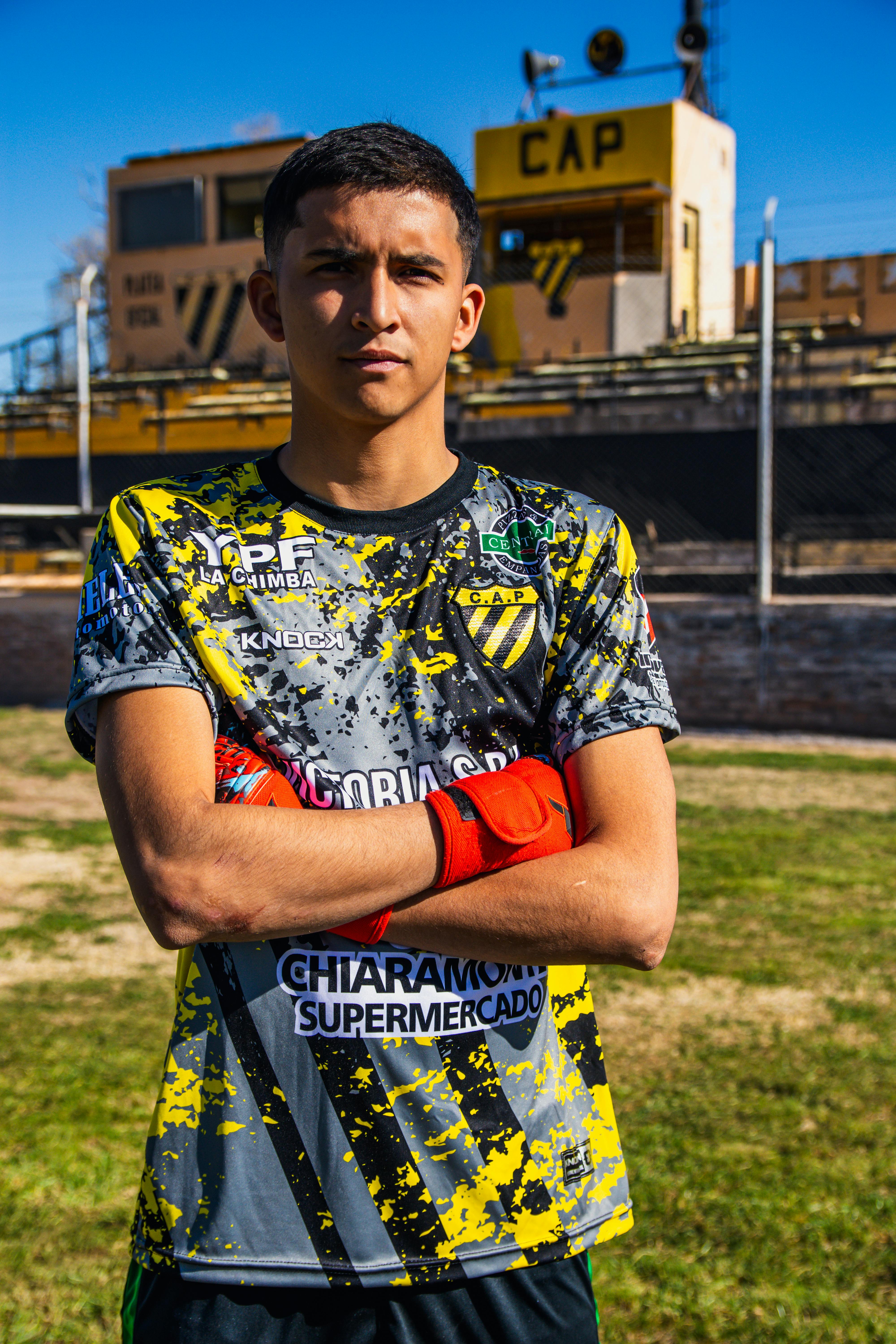 Portrait of a young soccer player standing confidently outdoors on the field.