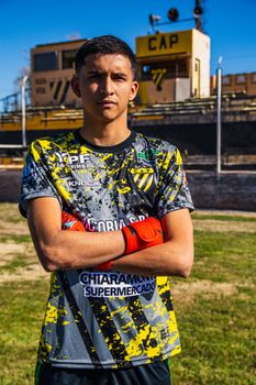 Portrait of a young soccer player standing confidently outdoors on the field.