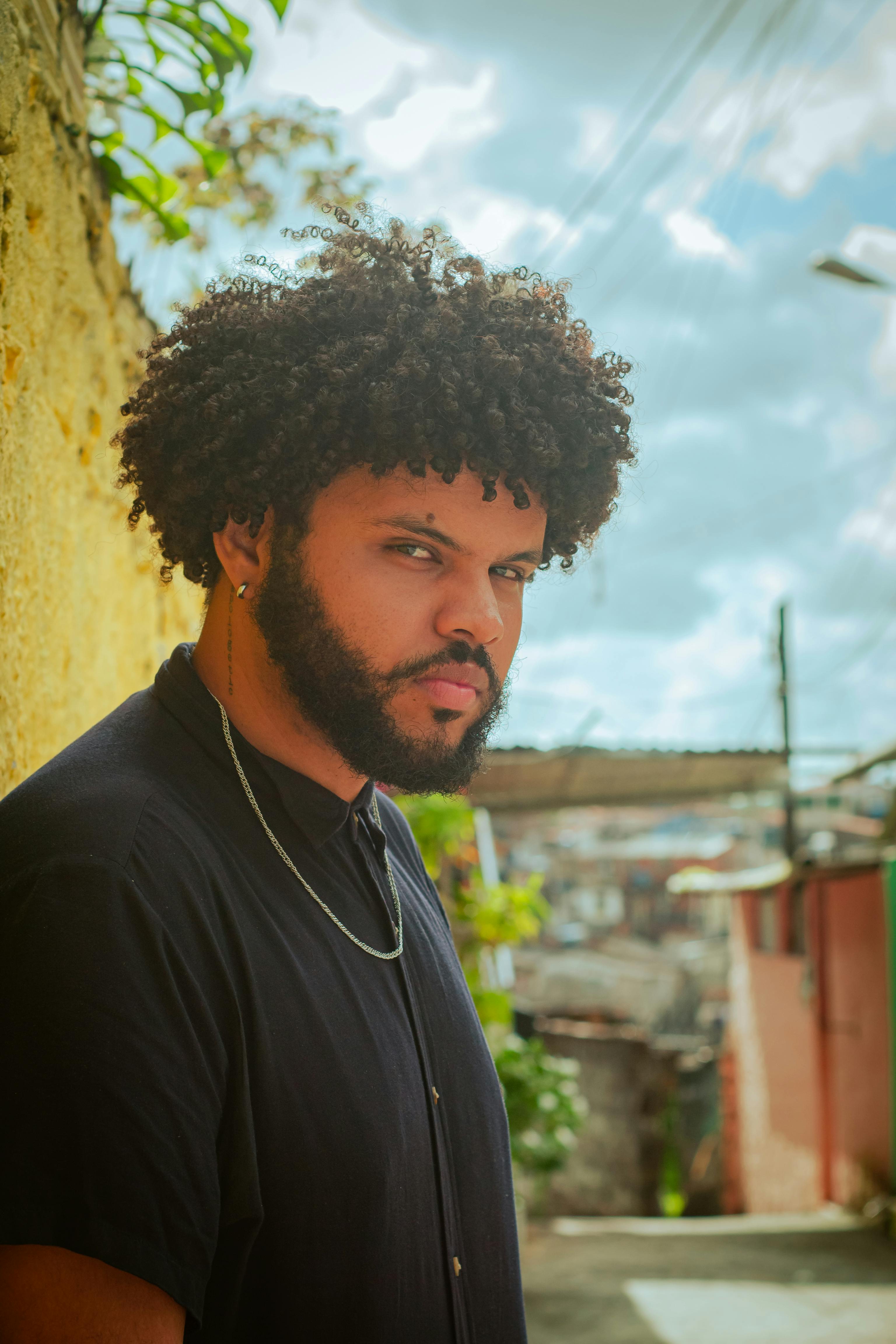Portrait of a fashionable musician outdoors in Recife, Brazil with a distinct afro hairstyle.