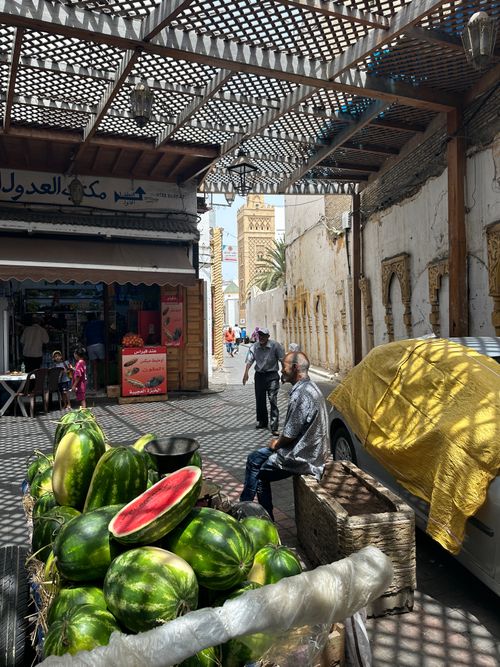 Free Traditional market scene with fresh watermelons and people in a Middle Eastern street. Stock Photo