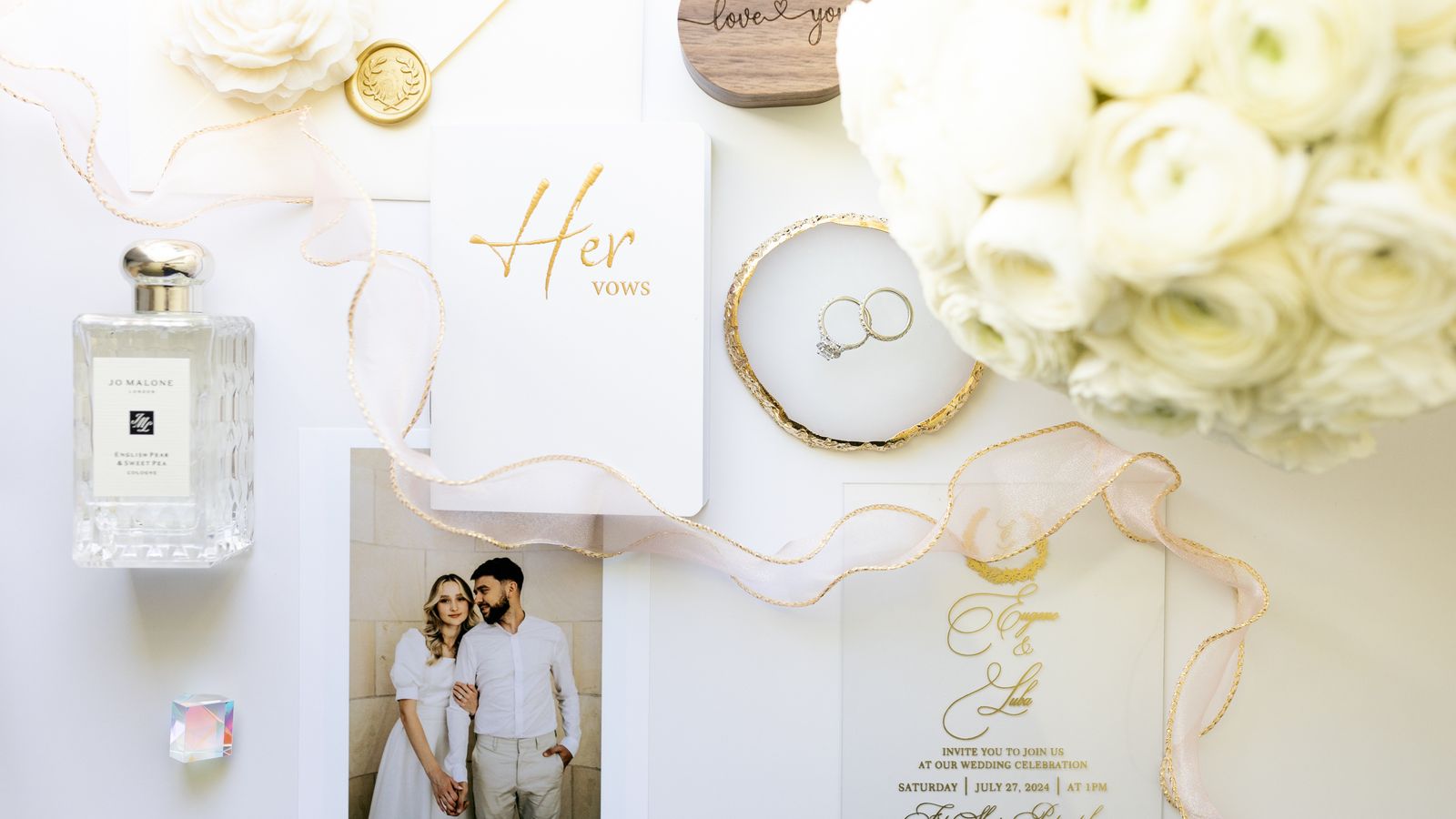 Wedding stationery, flowers and rings arranged on a table