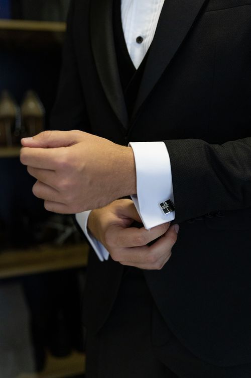 Free Close-up of a man in formal attire adjusting his cufflinks, emphasizing elegance and preparation. Stock Photo