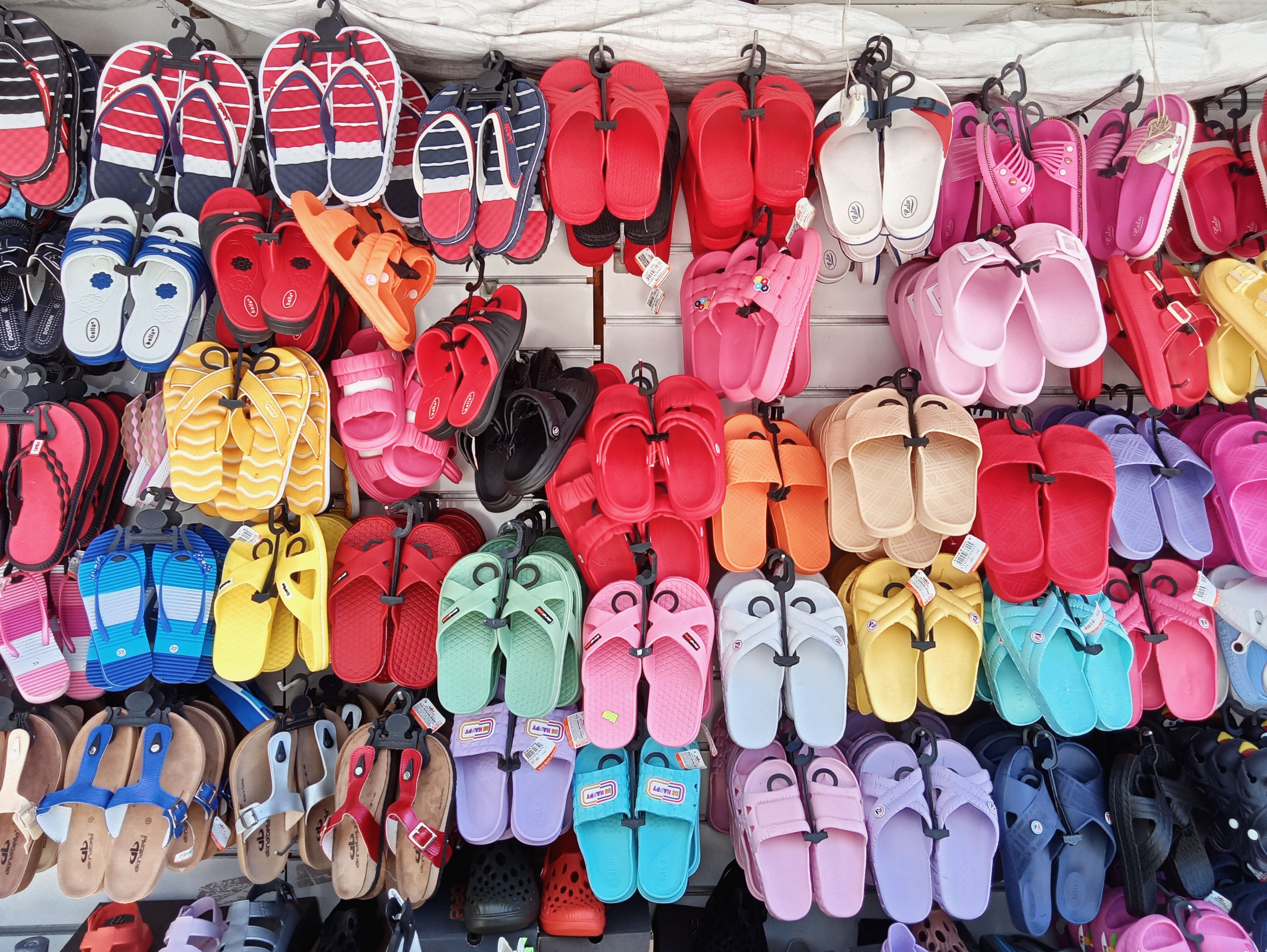 Bright, colorful sandals on display at a market in Balıkesir, Türkiye, ideal for summer fashion shopping.