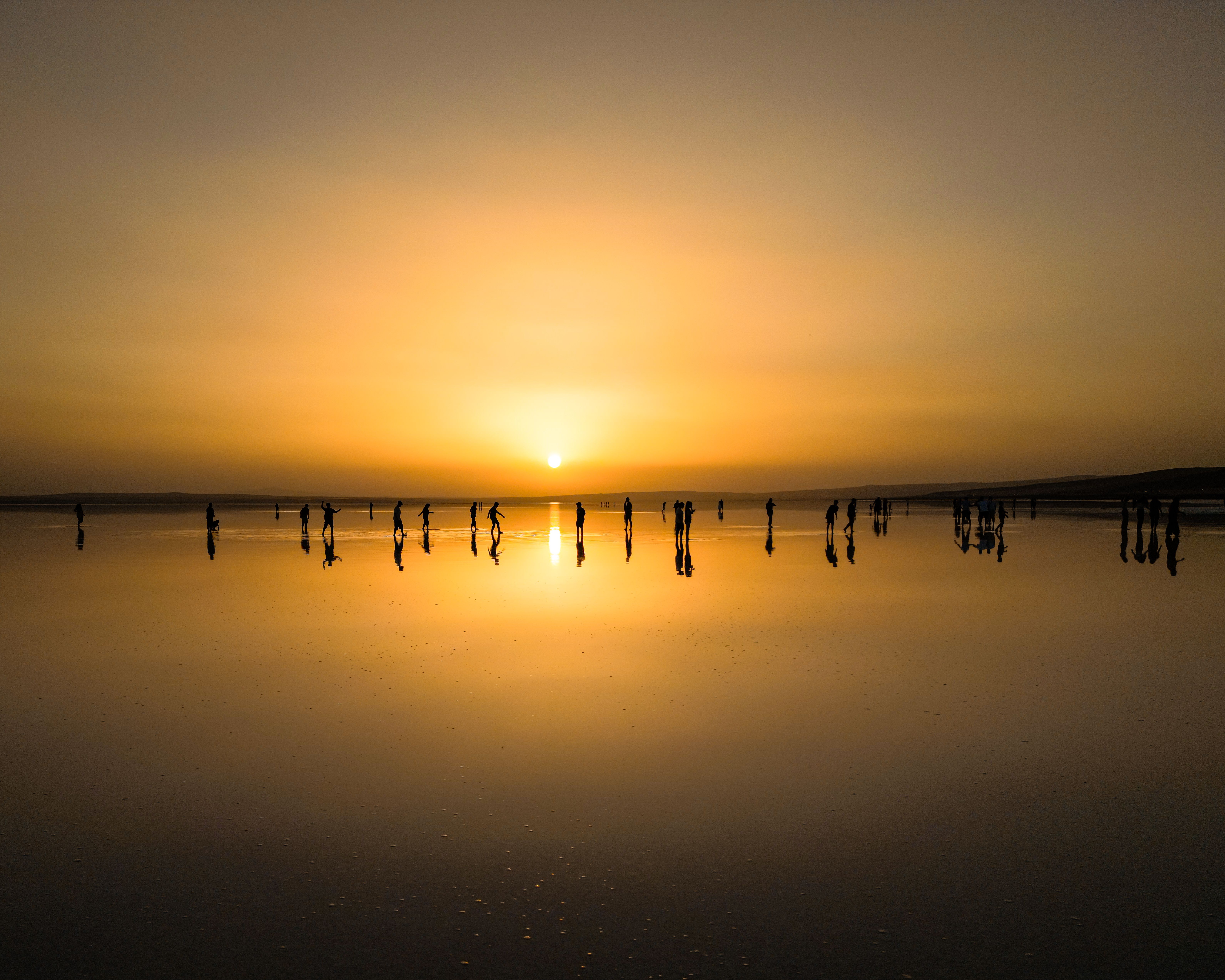 A sunset over a body of water with wooden posts, Djibouti