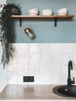 Minimalist kitchen with modern sink, elegant tiles, and wooden shelf decor.
