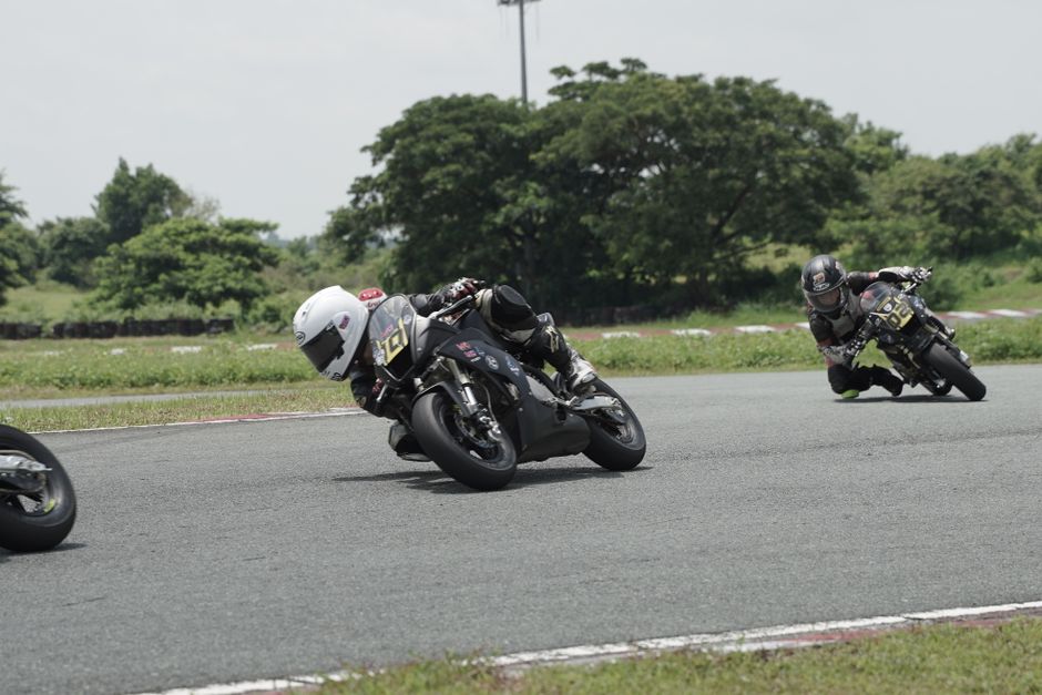 Riders engage in a thrilling motorcycle race on an outdoor circuit, showcasing speed and maneuverability.