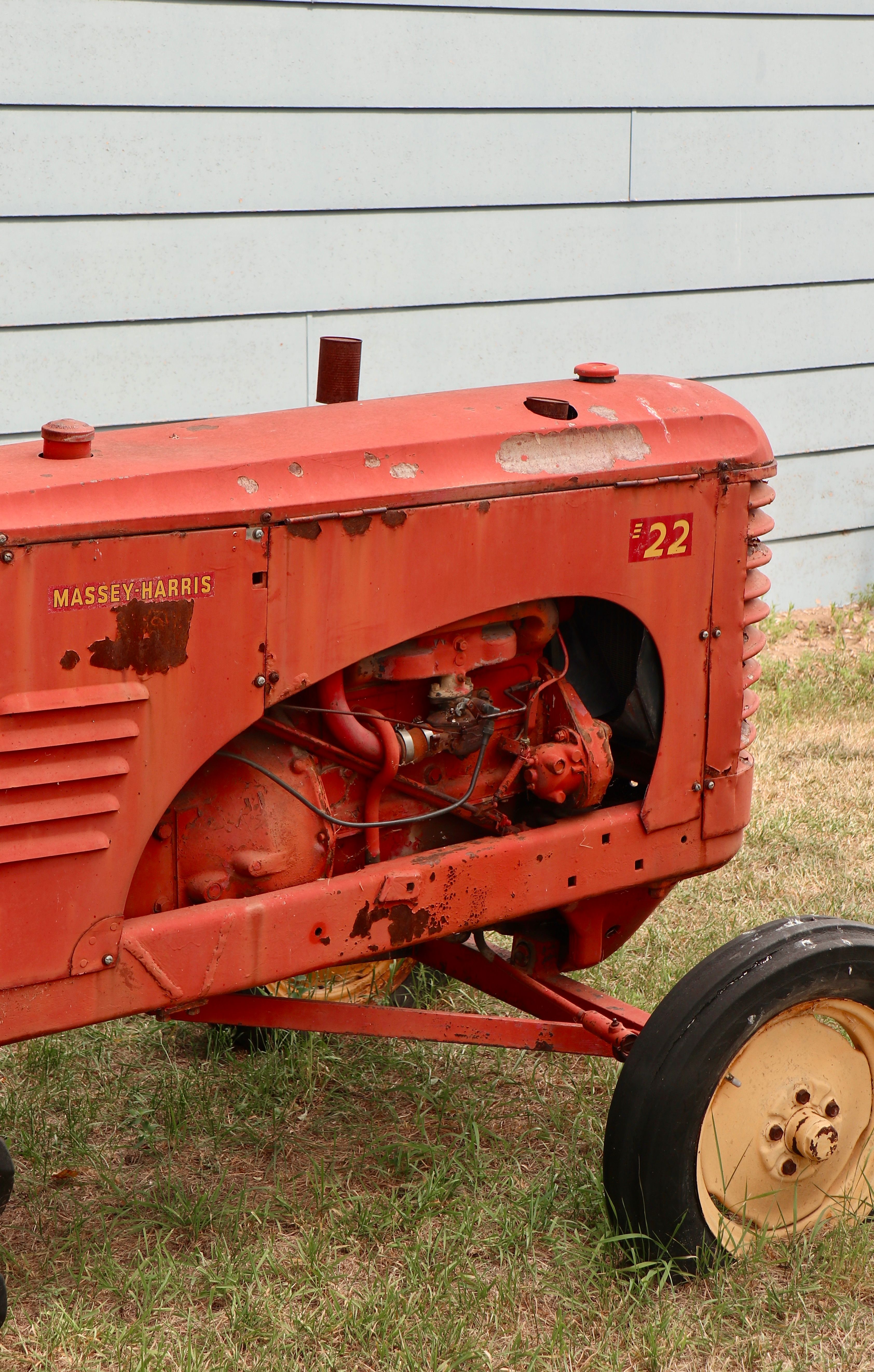 A red tractor sitting on the grass · Free Stock Photo