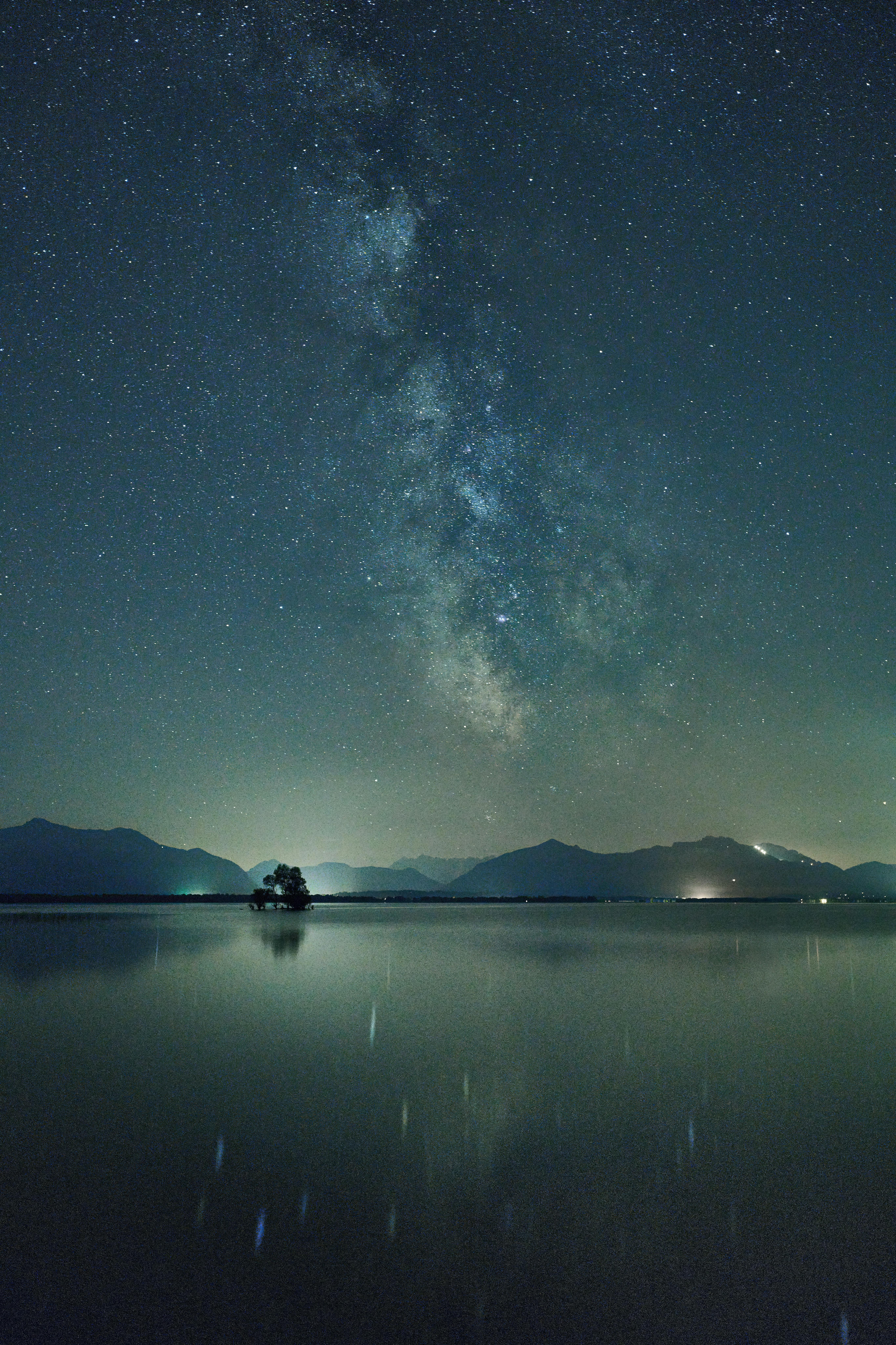 Glimmering Milky Way reflection over Chiemsee Lake on a clear night.