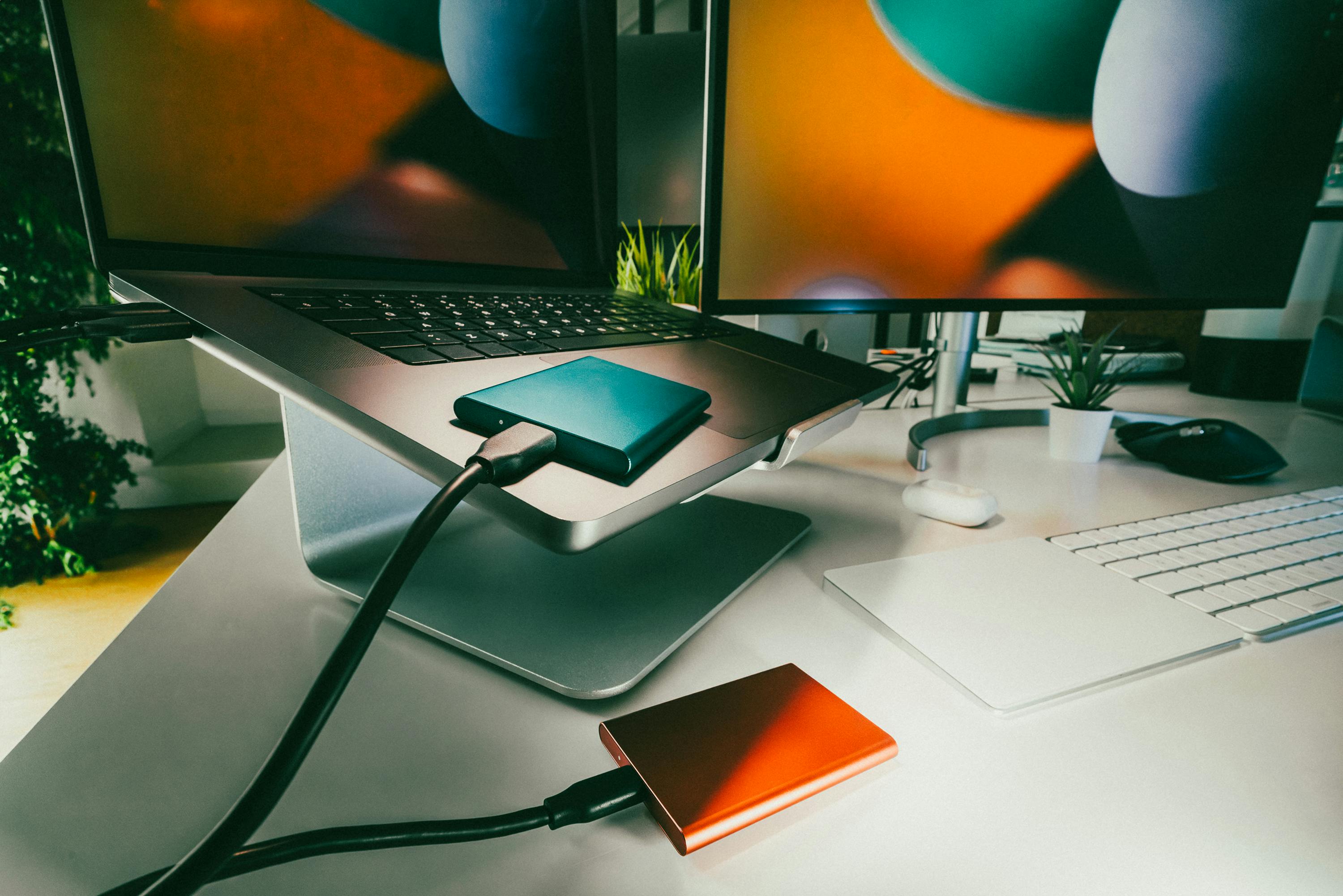 Stylish home office setup featuring laptop and external drives for data storage and backup.