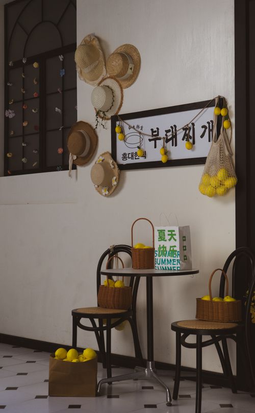 Free Stylish interior with hats, baskets of lemons, and summer-themed decor. Stock Photo