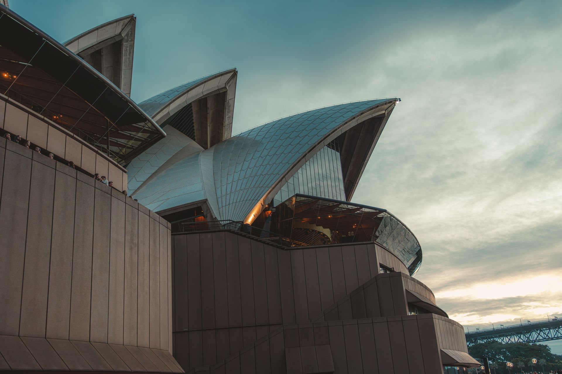 A dramatic view of the Sydney Opera House against a moody evening sky.