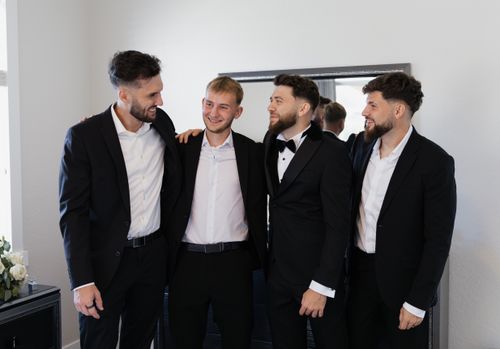 Free A joyful group of groomsmen and groom sharing a moment before a wedding ceremony. Stock Photo