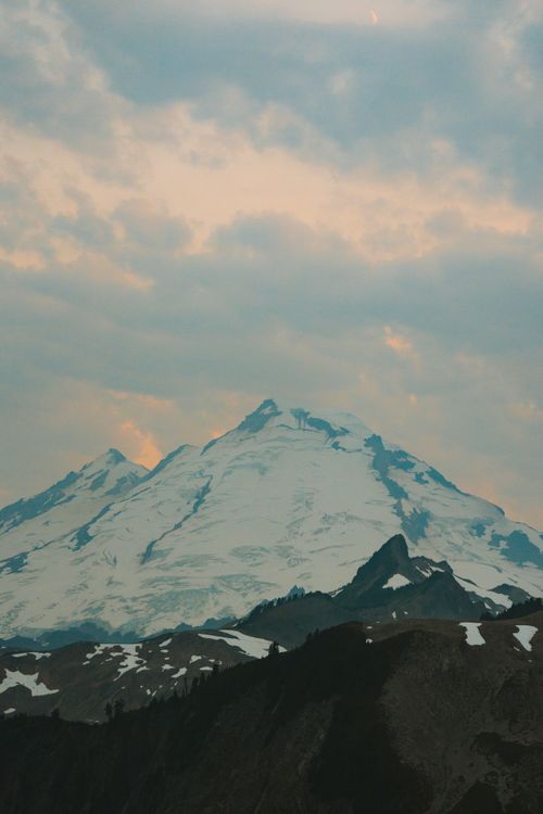 Free Majestic mountain peak with snow under a colorful dusk sky, ideal for travel and nature themes. Stock Photo