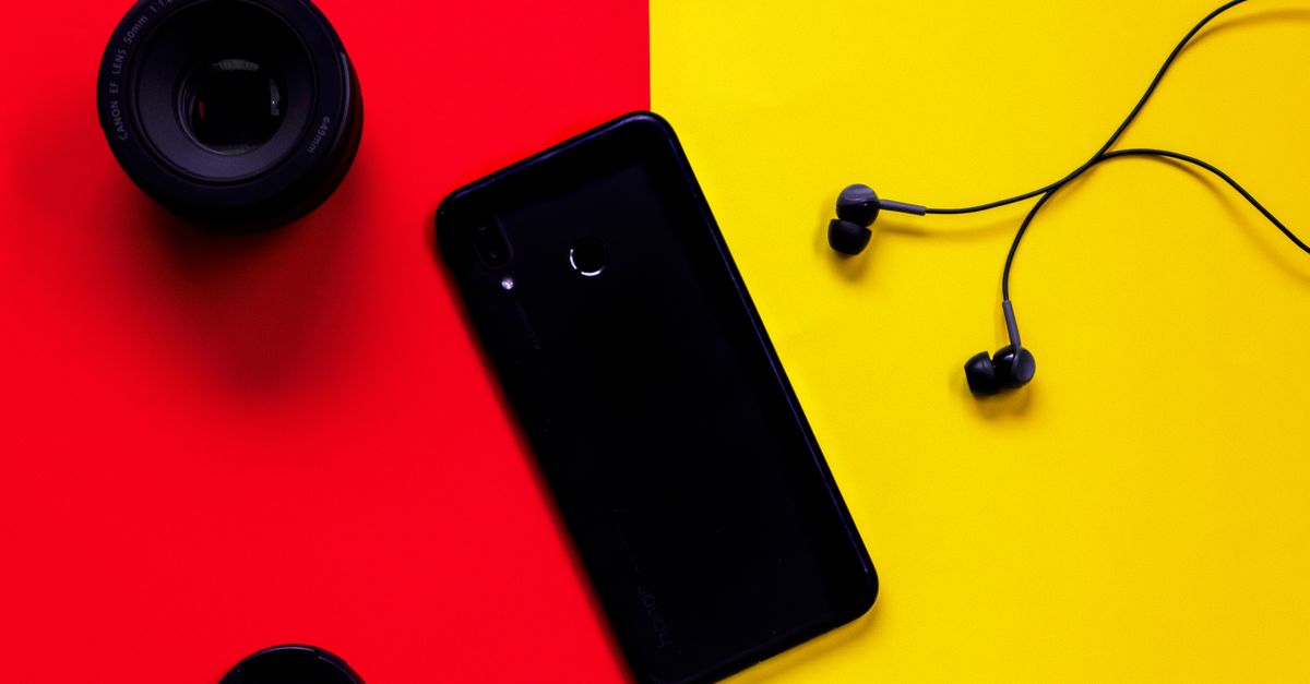 Retro digital camera and flip phone flat lay with Y2K accessories
