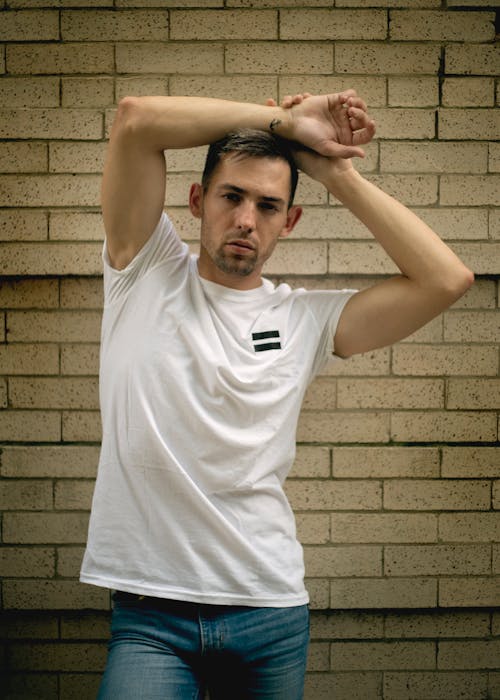 Photo Of Man Standing Beside A Wall