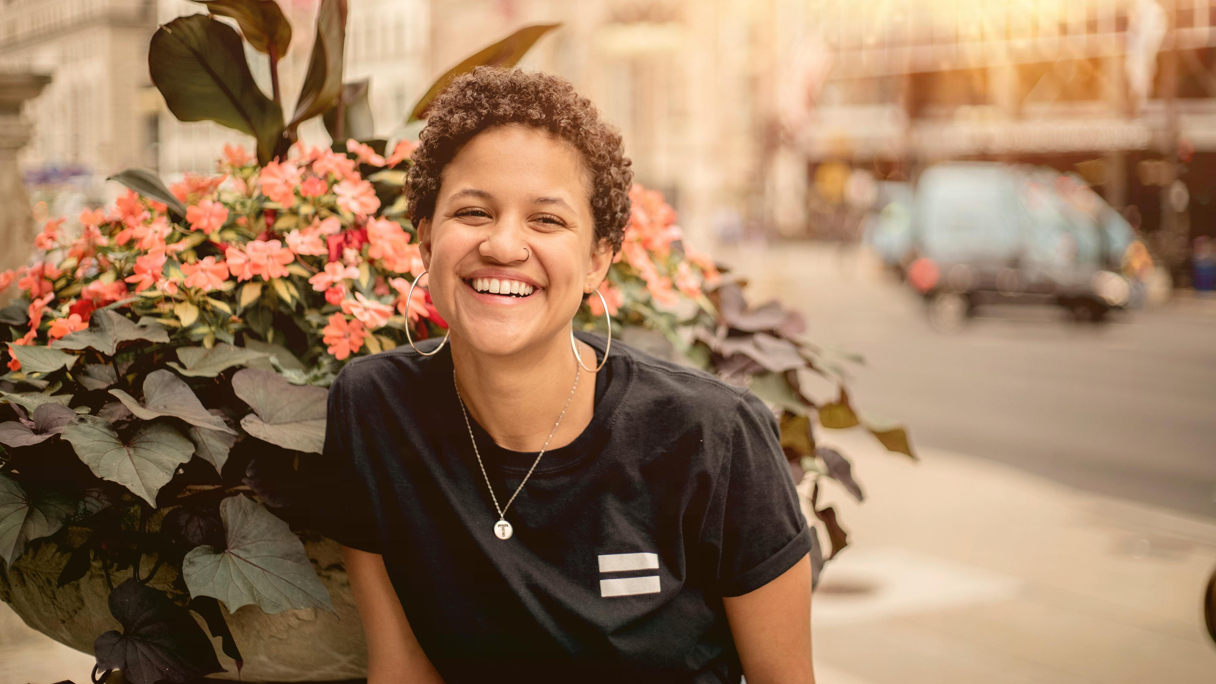 在阳光明媚的日子里，一位快乐的女子在芝加哥市区，被鲜花包围着微笑
