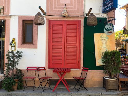 Free Colorful outdoor café with red chairs and table in Ayvalık, Türkiye. Stock Photo