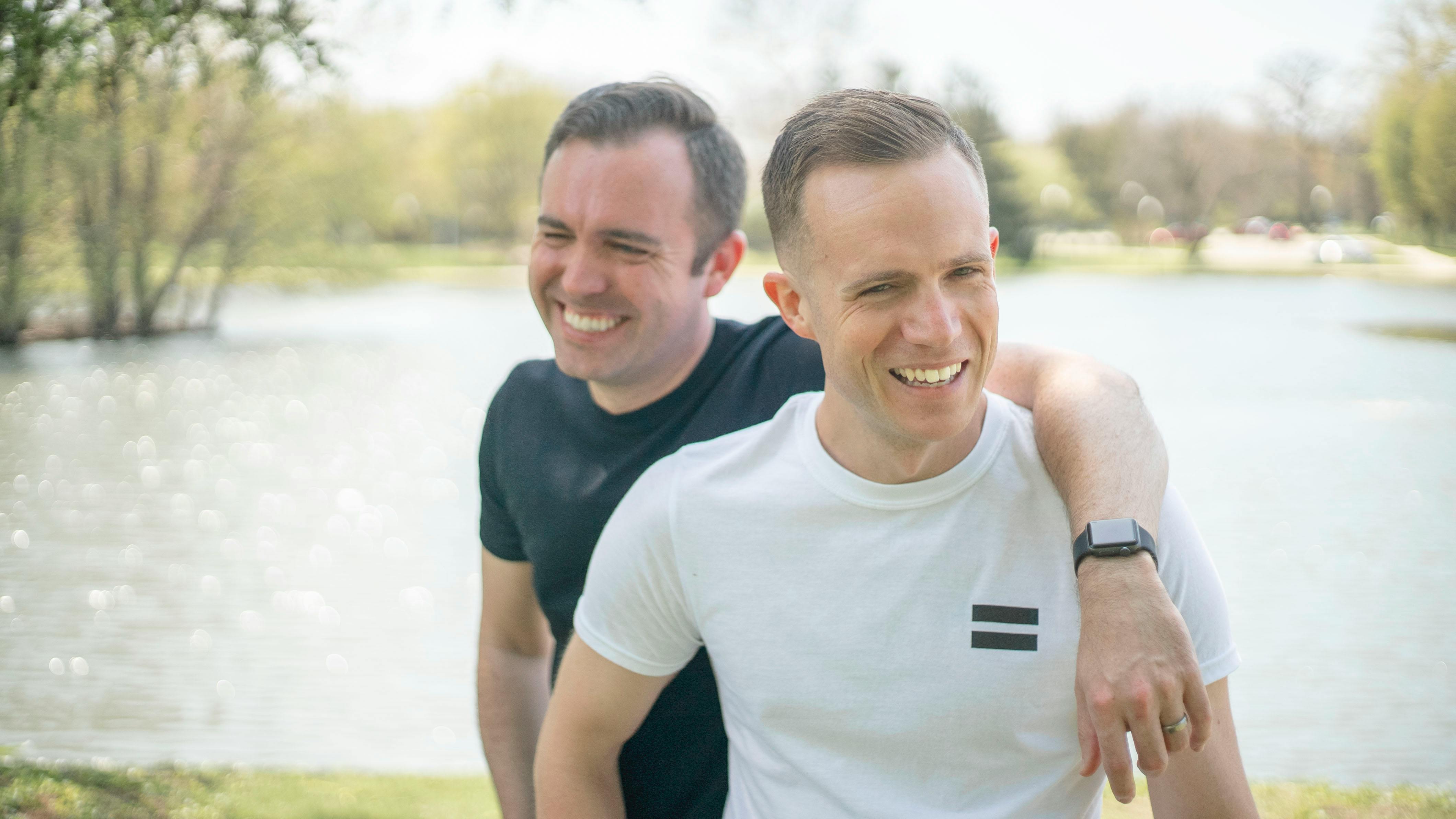 close up photo of two friends standing and laughing together