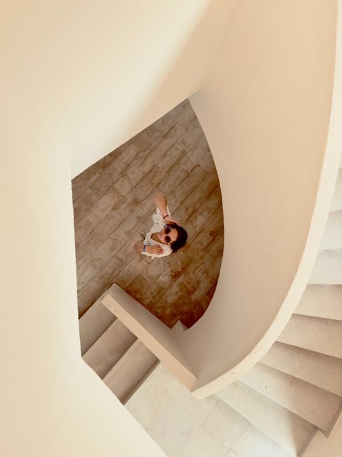 Free Top view of a woman climbing a spiral staircase inside a modern building in Médenine Governorate, Tunisia. Stock Photo