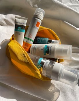 Assorted skincare products in a yellow pouch, captured in natural lighting.