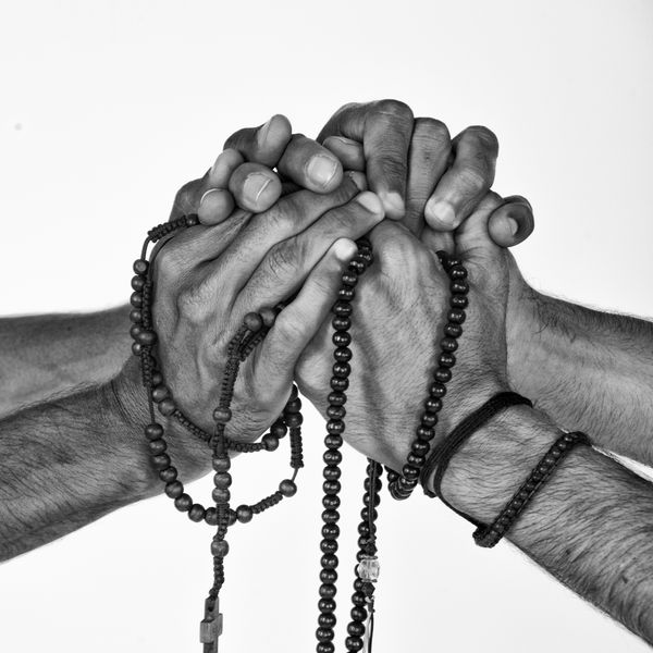 Black and white photo of two hands clasped together — photo by Christian Buehner on Pexels