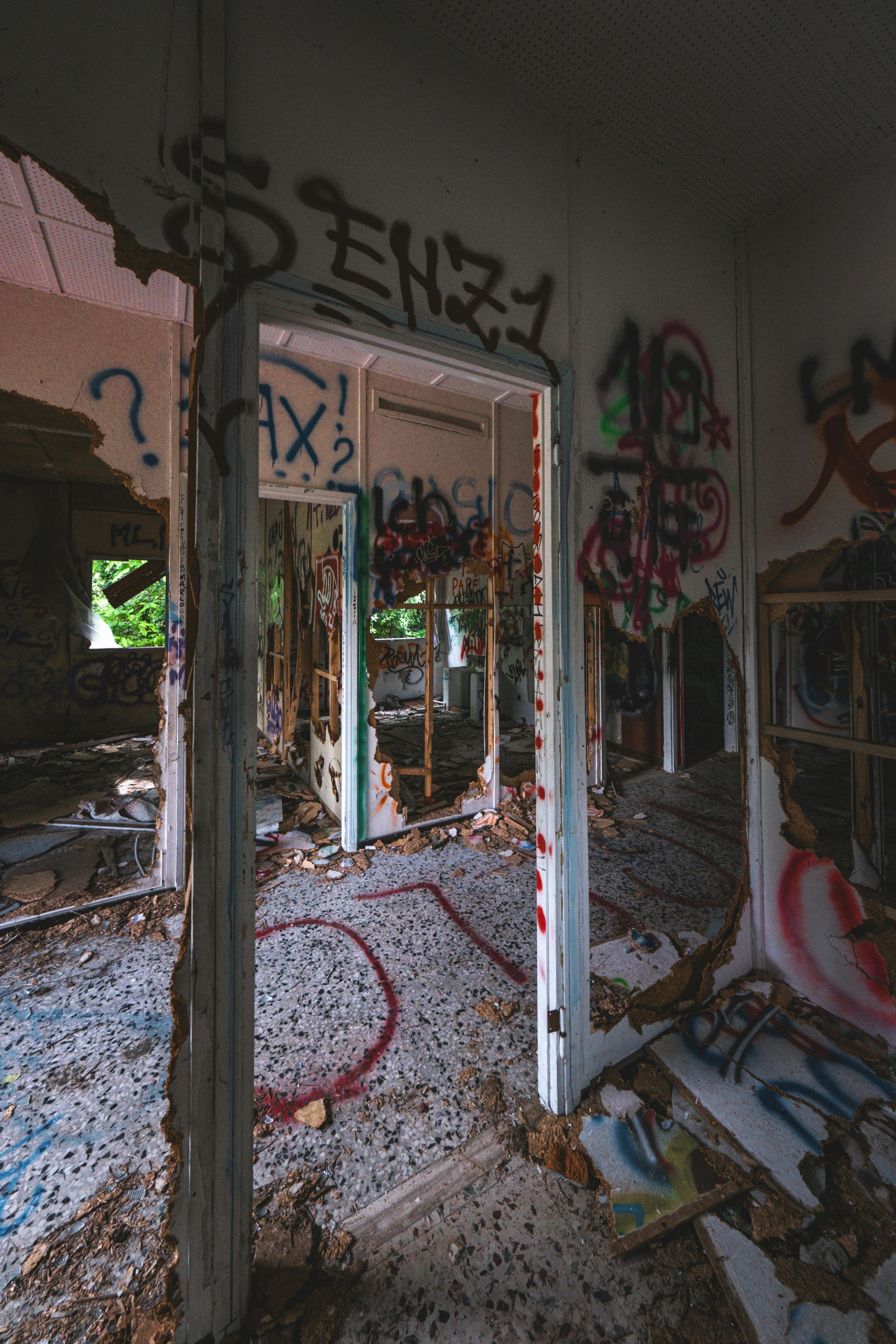 An abandoned building with walls covered in vibrant graffiti art and visible decay.