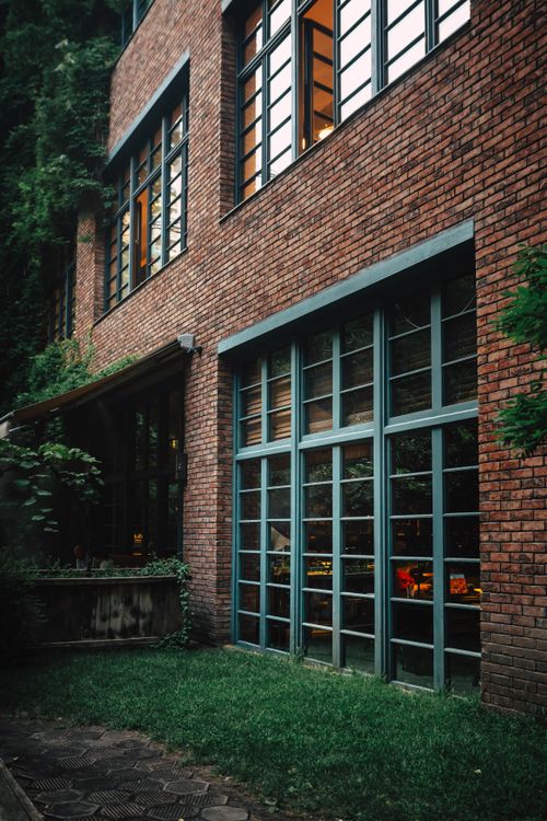 Free A modern brick building exterior with glass windows and greenery in Tbilisi, Georgia. Stock Photo