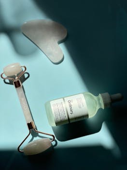 A serene composition featuring a jade roller, gua sha, and skincare serum in soft lighting.