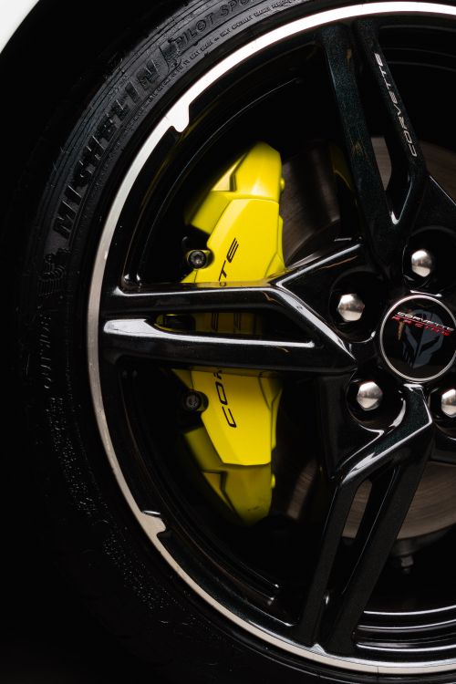 Free Detailed shot of a Chevrolet Corvette wheel rim with a bright yellow brake caliper. Stock Photo