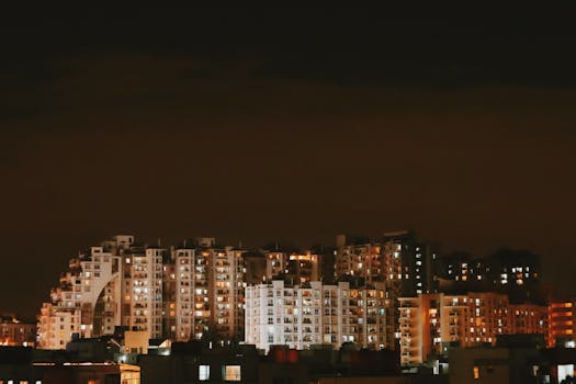 A vibrant city skyline at night with illuminated buildings reflecting urban life.