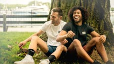 两个朋友在芝加哥公园里，笑着享受阳光明媚的一天