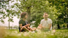 两个朋友在芝加哥公园享受阳光明媚的一天，在户外分享欢笑和放松