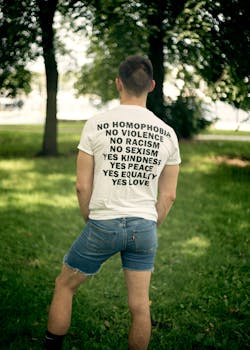 Back view of a man in a park advocating love and equality on a T-shirt.