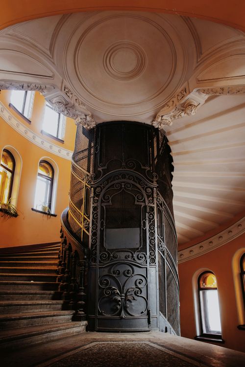 Free A beautifully ornate spiral staircase inside a historic building with intricate metalwork. Stock Photo