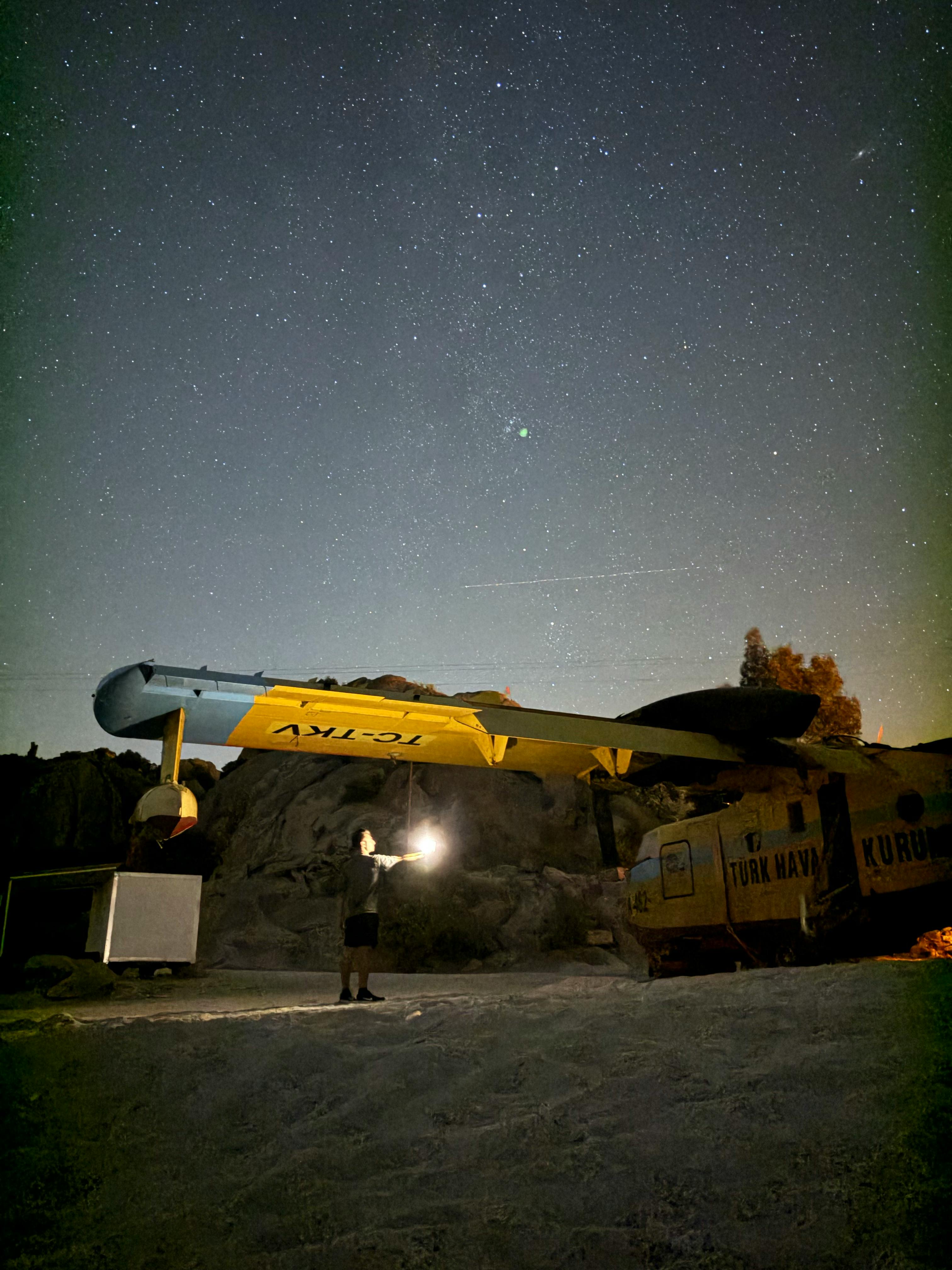 a man standing next to a large yellow object under the night sky