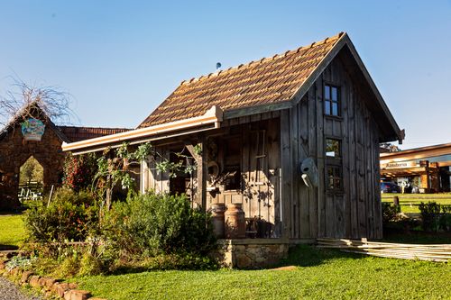 Free Charming rustic wooden cabin surrounded by lush greenery on a sunny day perfect for travel inspiration. Stock Photo