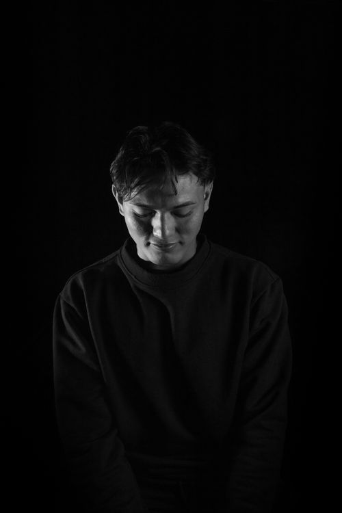 Free Black and white portrait of a man in a studio with dramatic lighting. Stock Photo