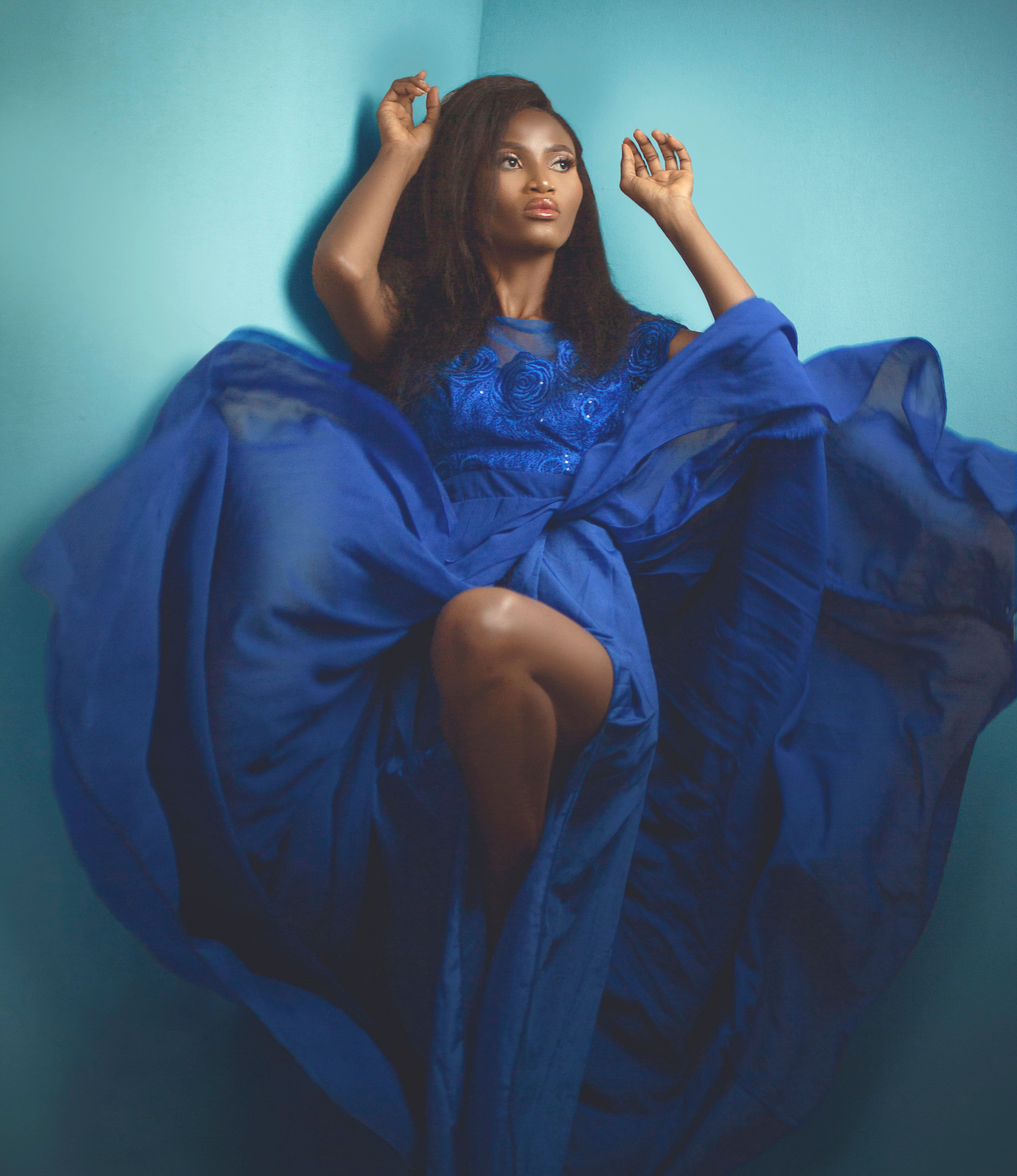 A woman in a blue dress sitting on the floor · Free Stock Photo
