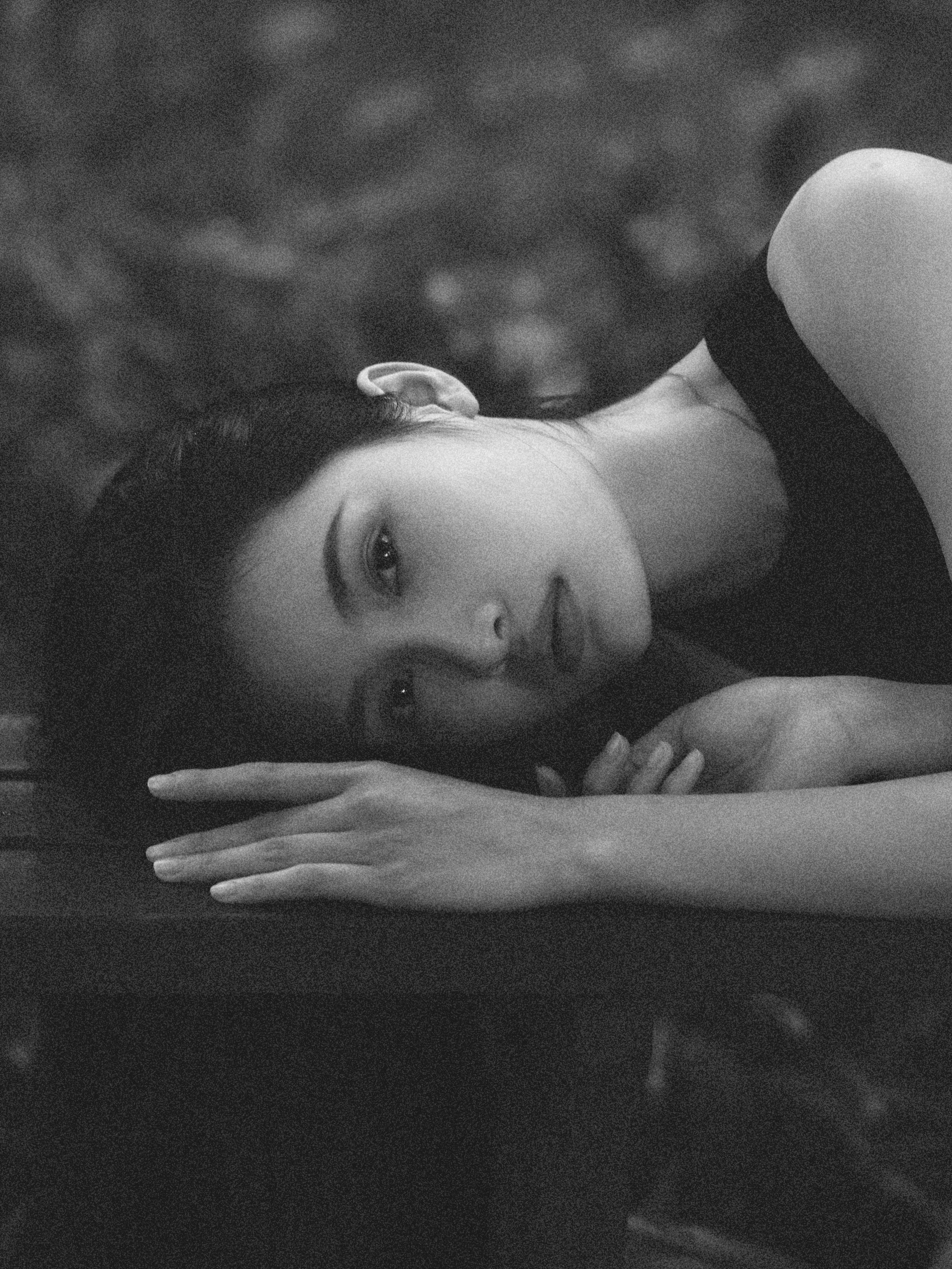 A woman laying on a bench in black and white · Free Stock Photo