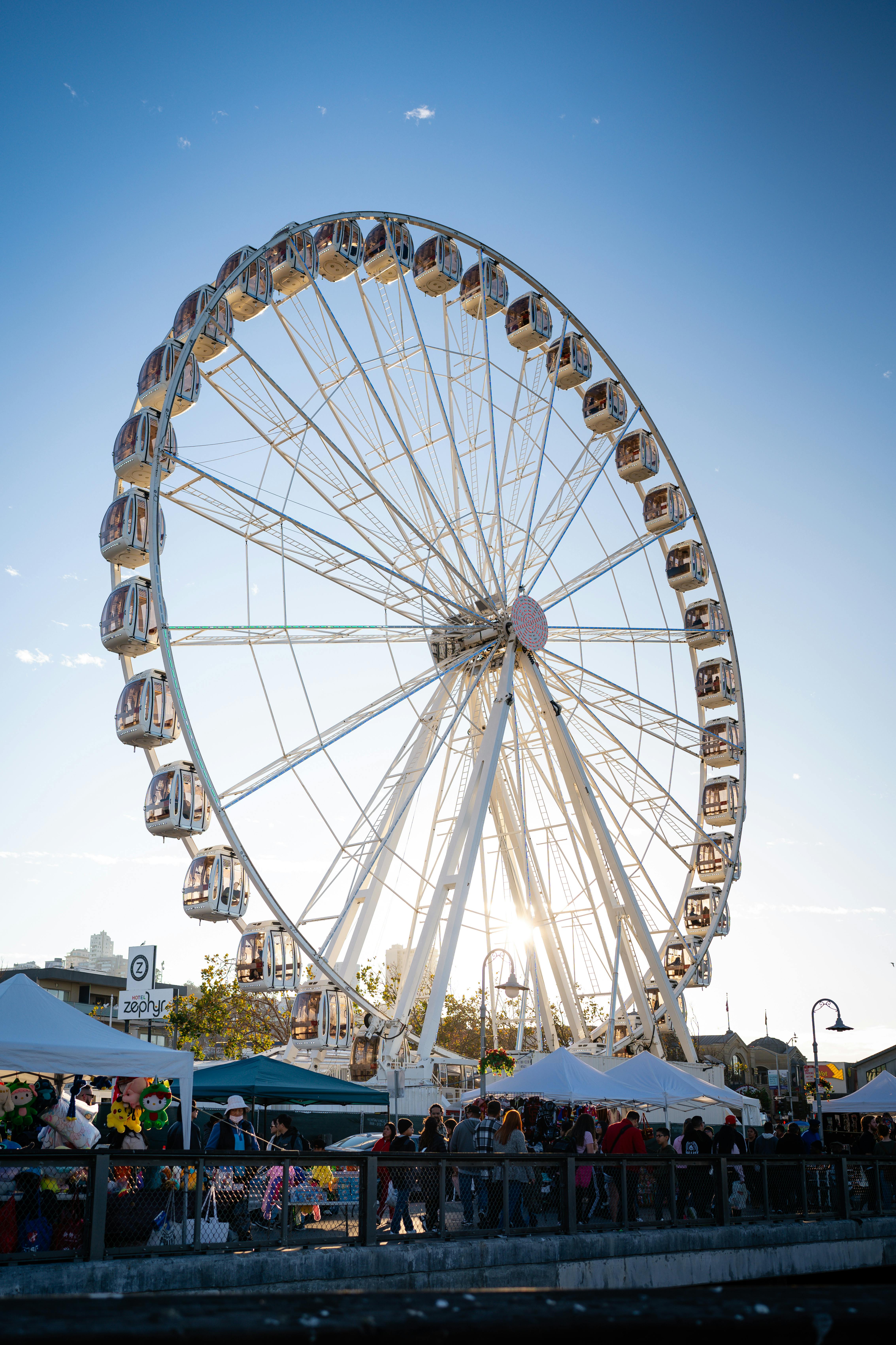 A large Ferris wheel towering over a bustling fairground at sunset, offering a thrilling view.