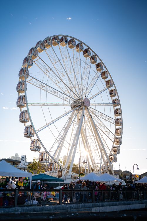 Free A large Ferris wheel towering over a bustling fairground at sunset, offering a thrilling view. Stock Photo