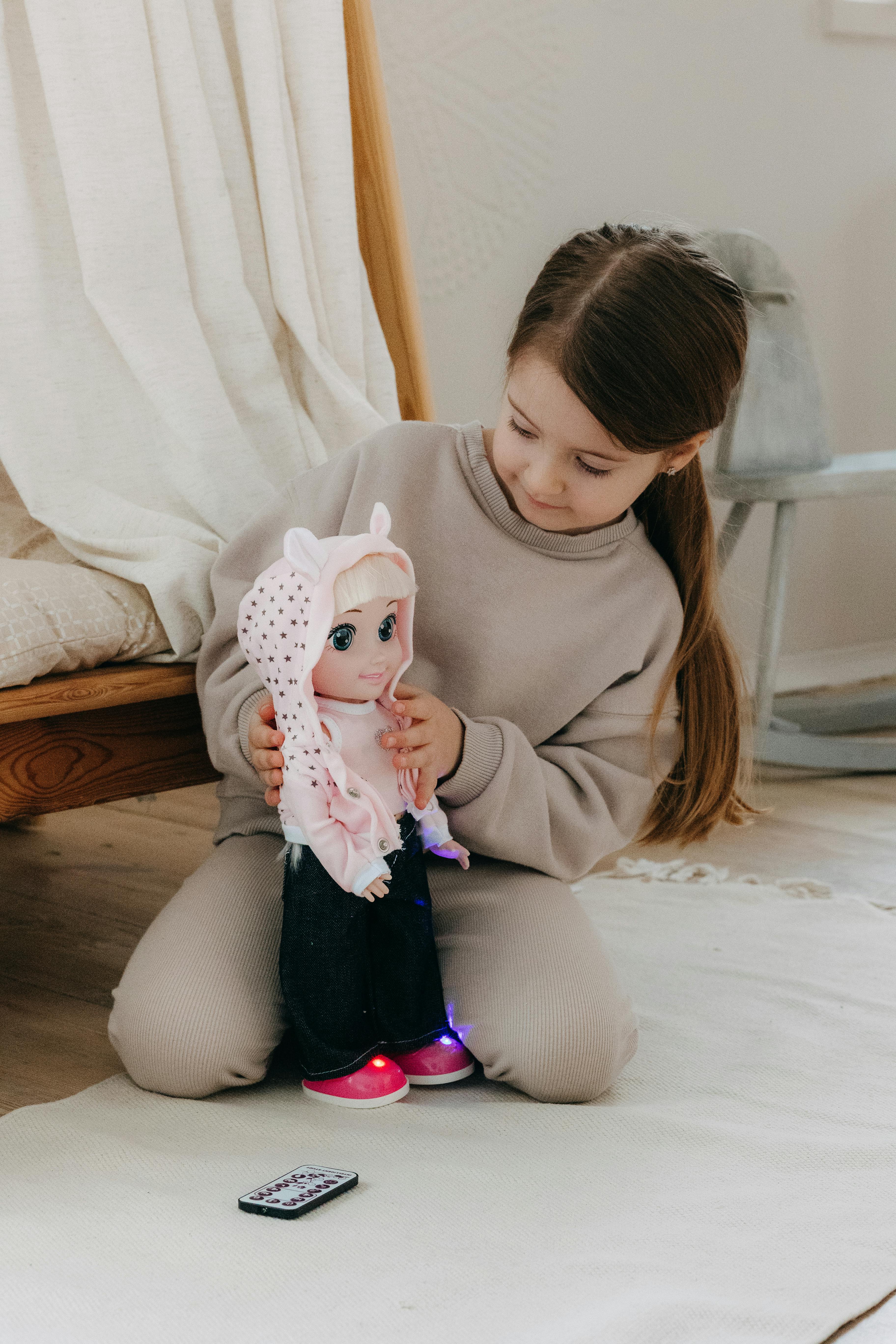 a little girl is playing with a doll on the floor