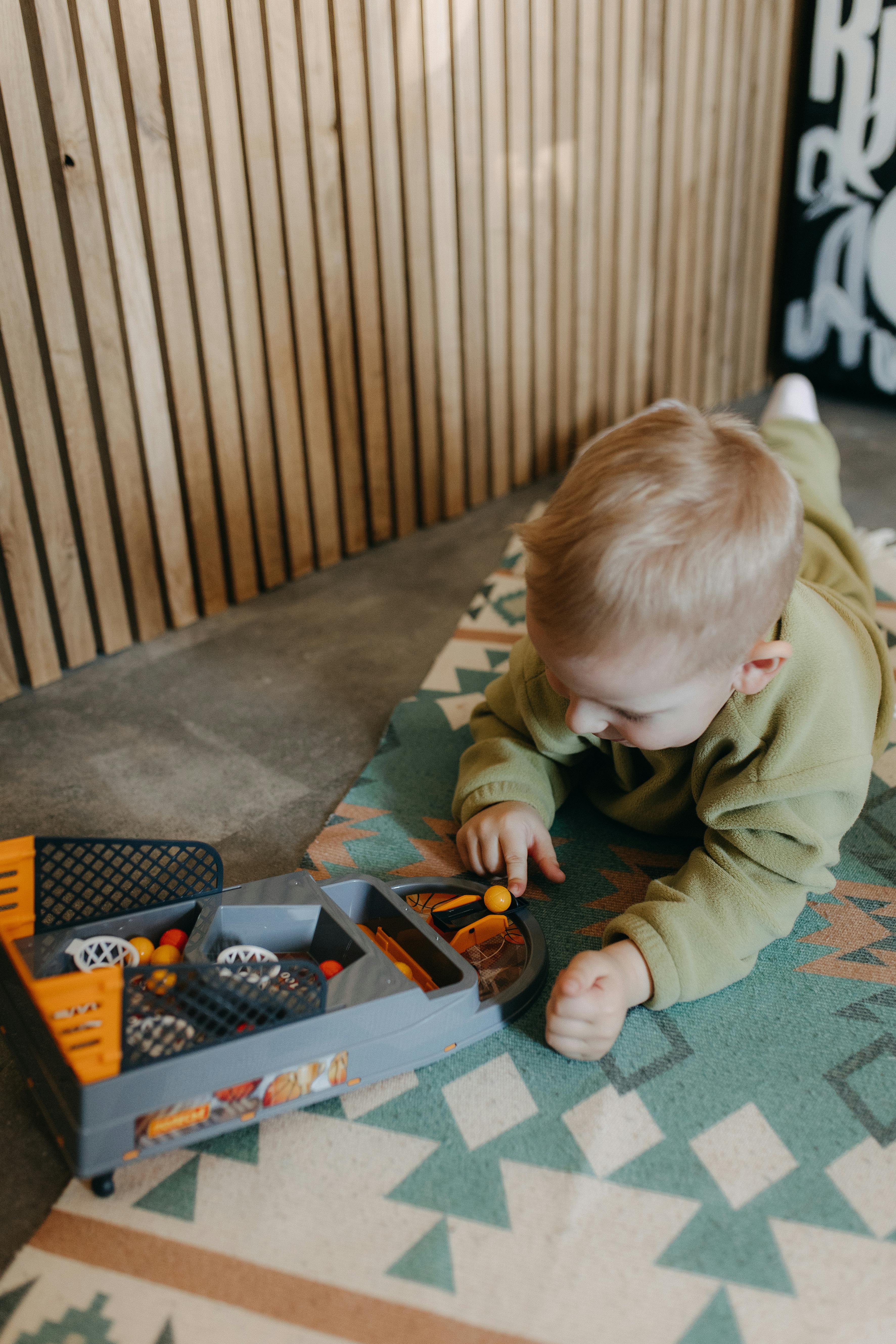 a toddler playing with a toy truck on a rug