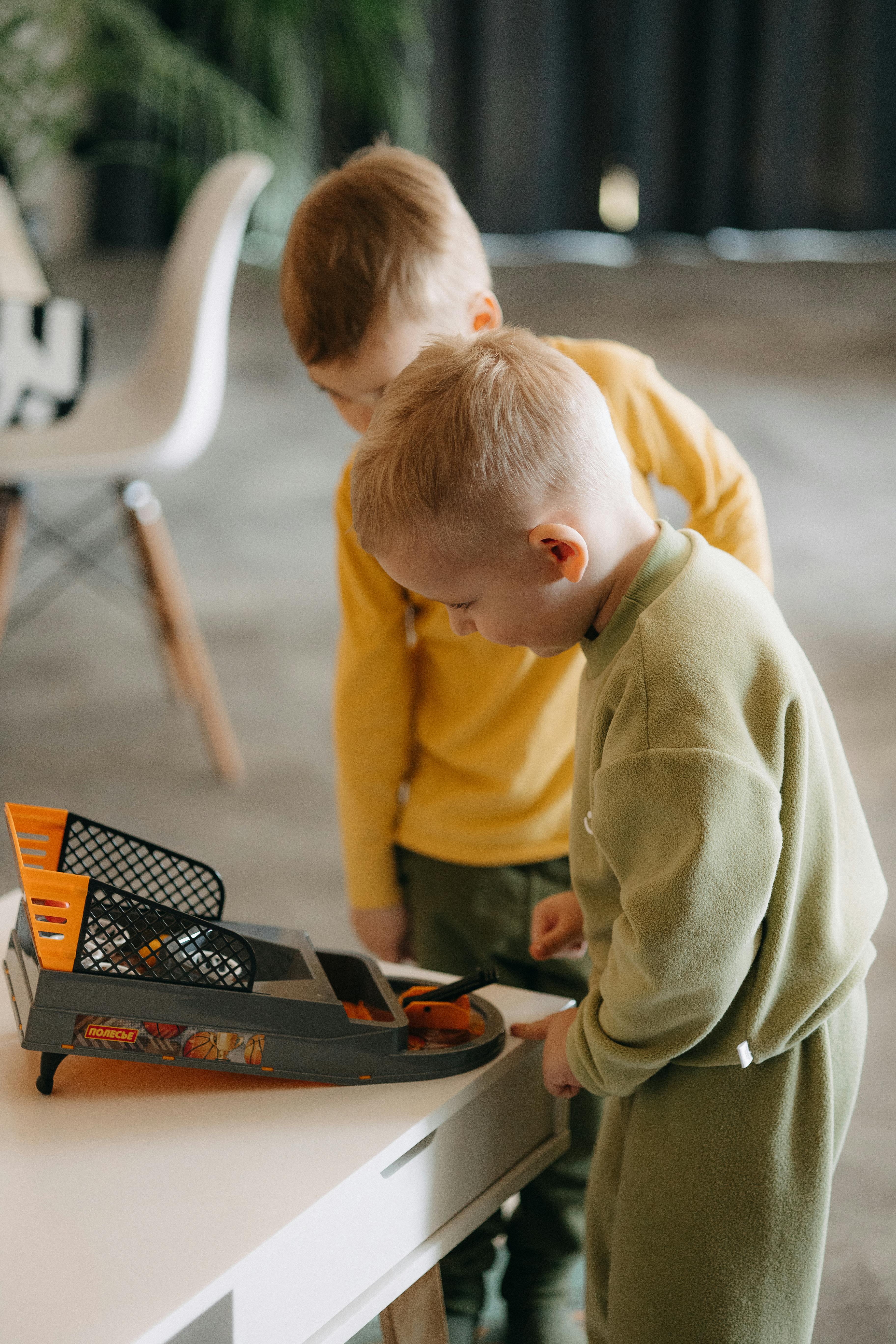 two young boys playing with a toy car