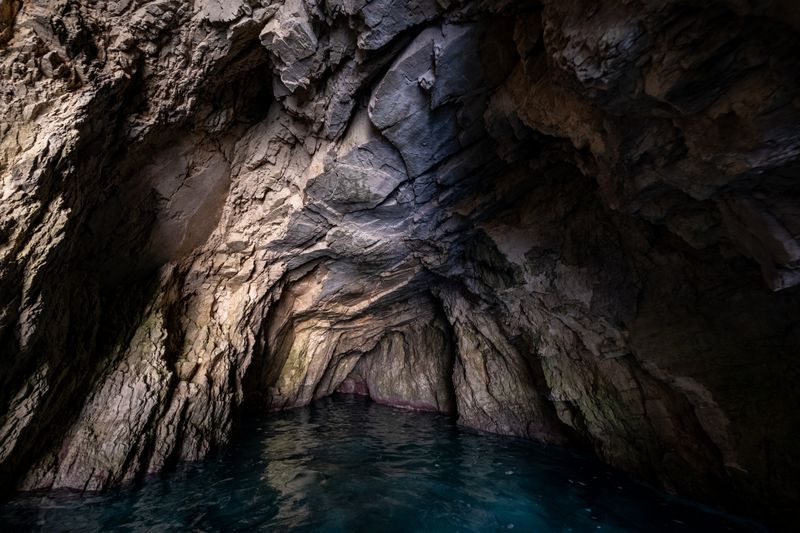 The dark interior of a sea cave opening to daylight — photo by Francesco Ungaro on Pexels