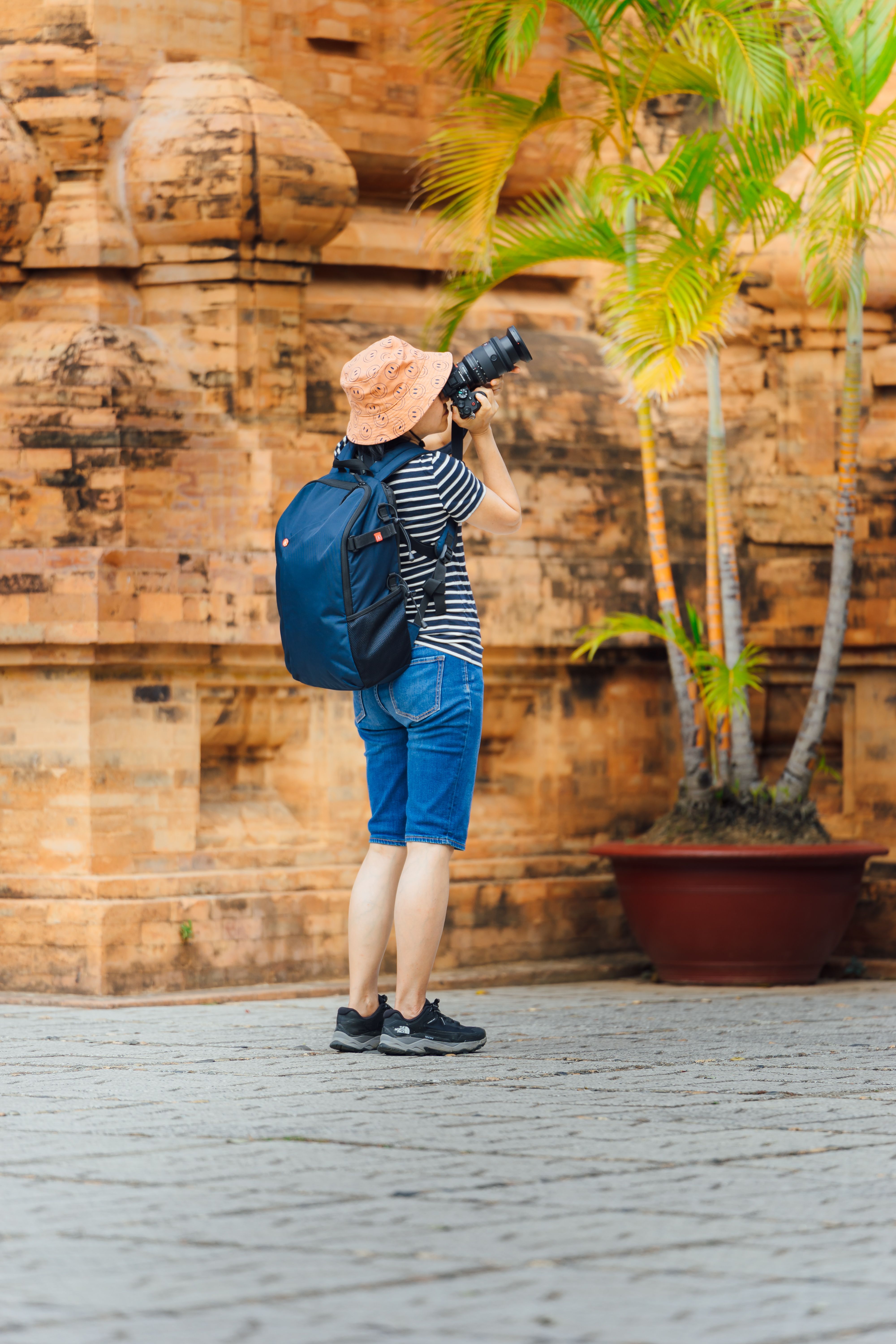 A traveler with camera photographing ancient architecture in a vibrant setting.
